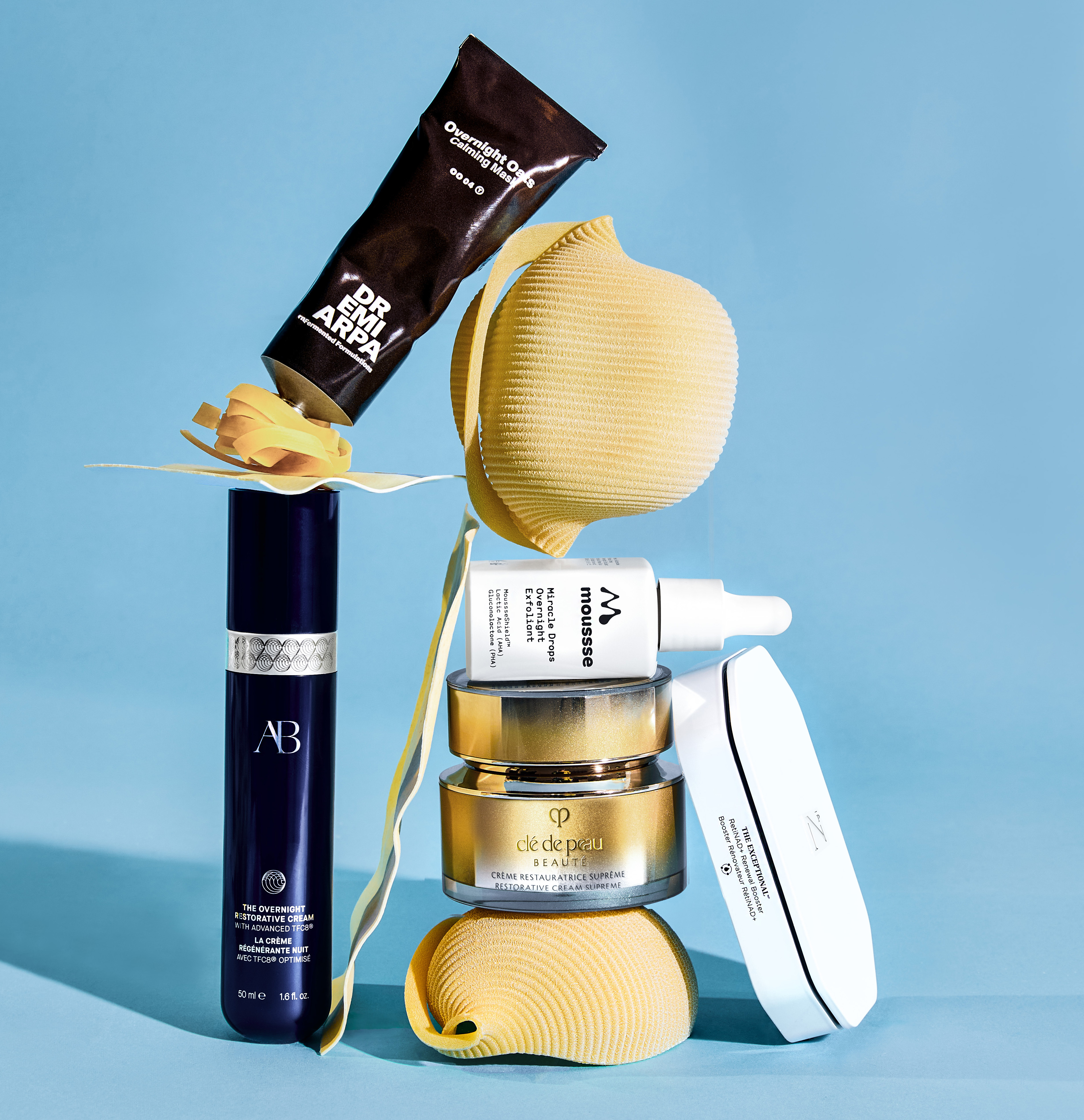 Skincare products and beauty tools against a blue background